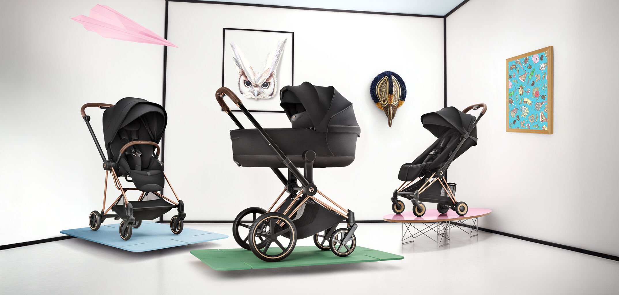 Three CYBEX Platinum strollers next to each other, a picture of an owl in the background.