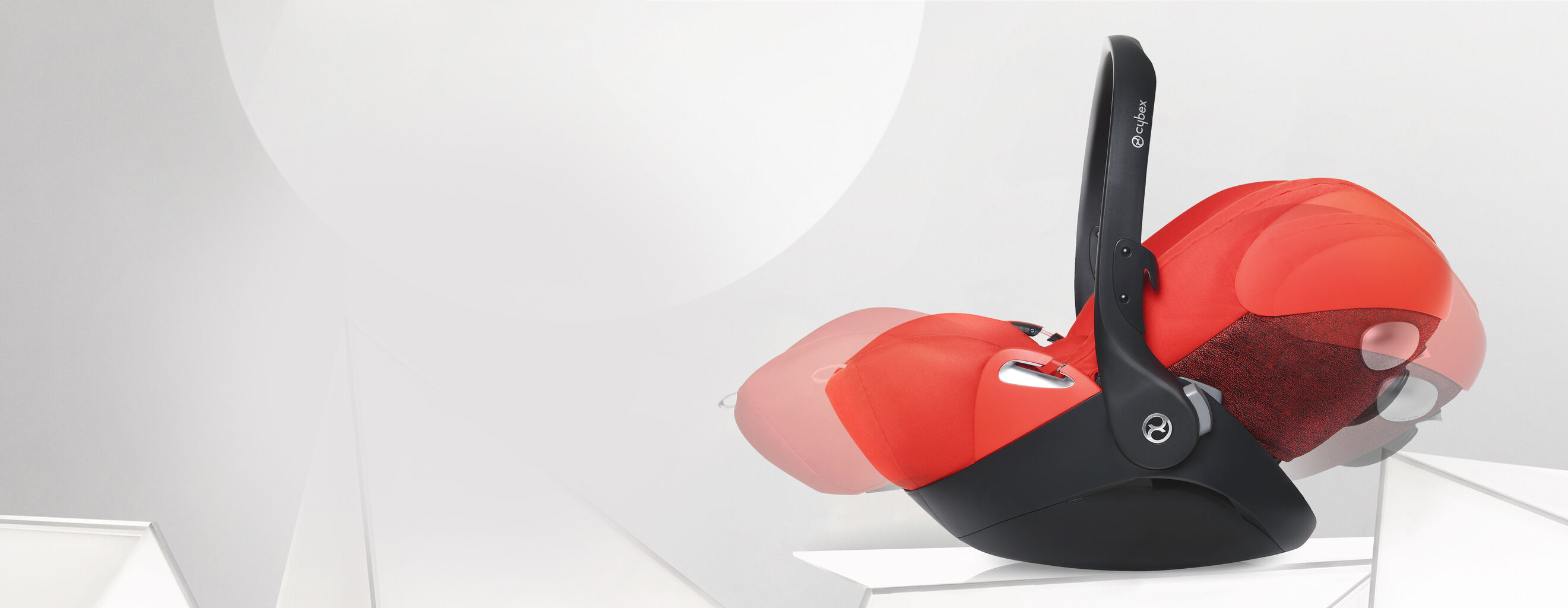 Cloud Q designer infant car seat in red and black on a grey background.