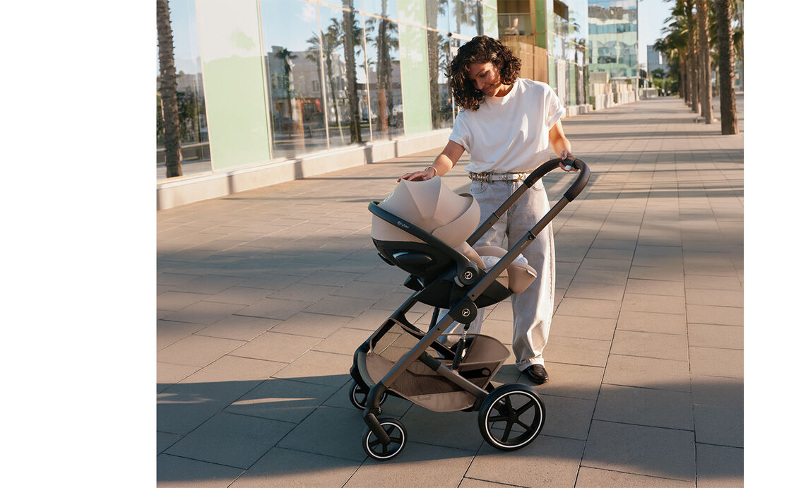 A mother adjusting the sun canopy of her Cloud G infant car seat attached to a Balios S Lux.