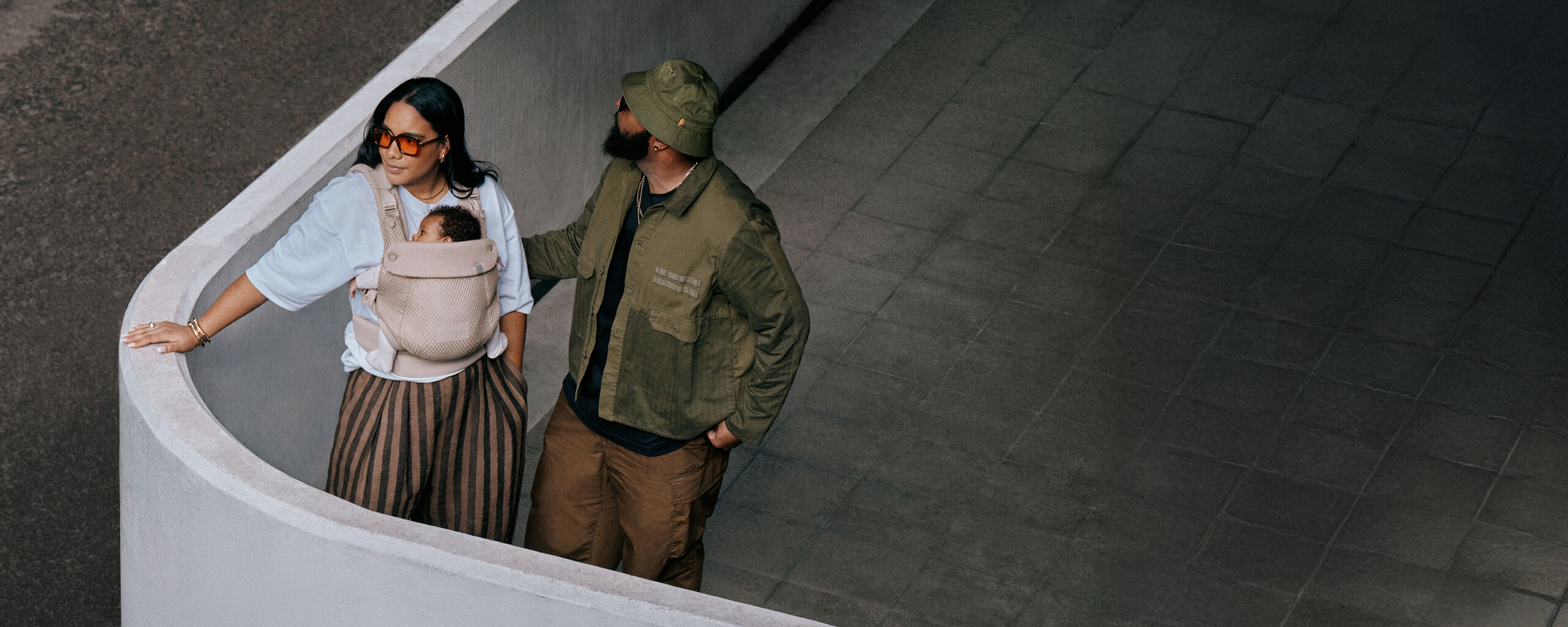 A man and a woman from an upper view. The woman is carrying her baby in an Amya baby carrier.
