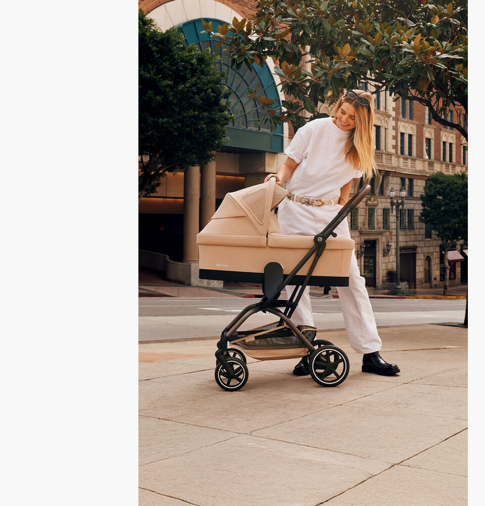 A mother checking on her baby in an Eezy S Twist +2 with a Cot attached.