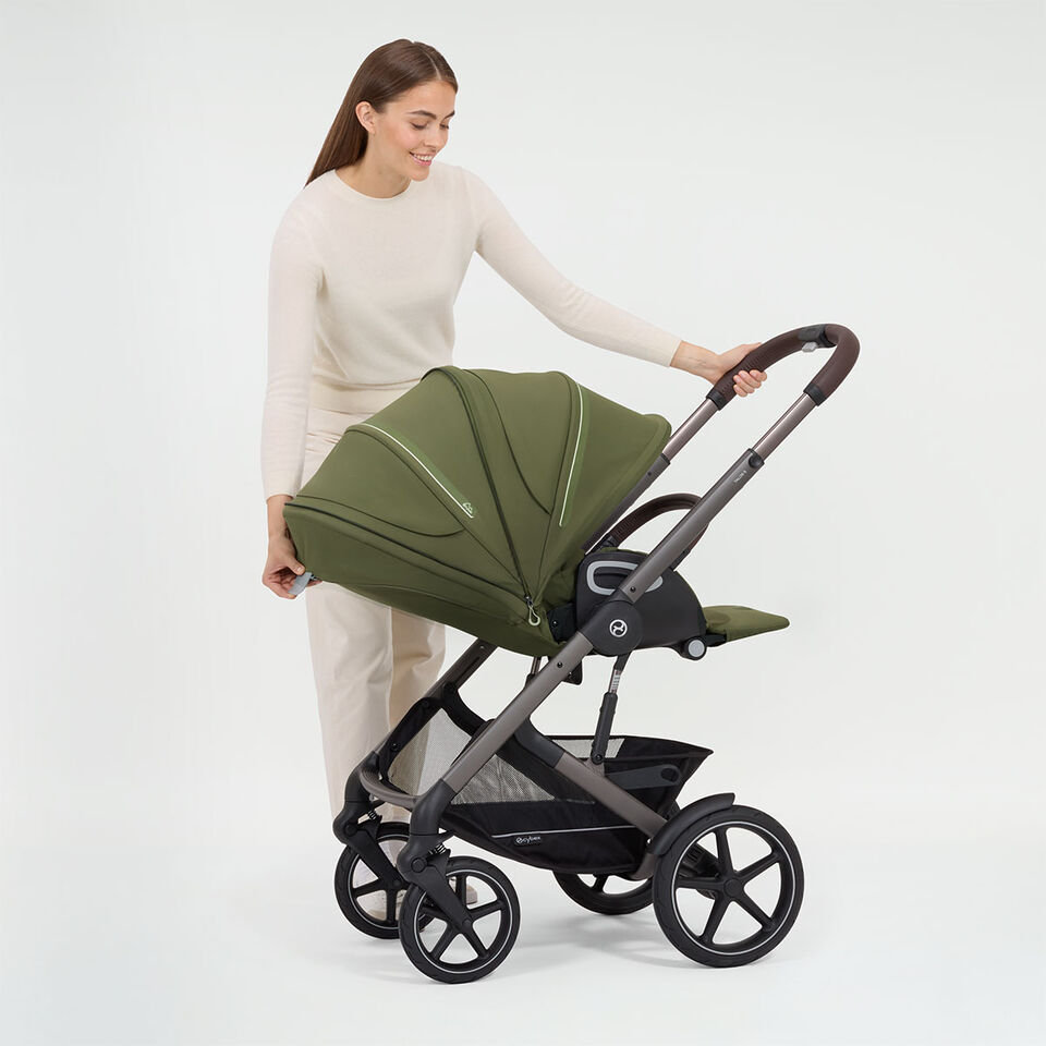 A woman reclining the backrest of her Talos S Lux stroller.