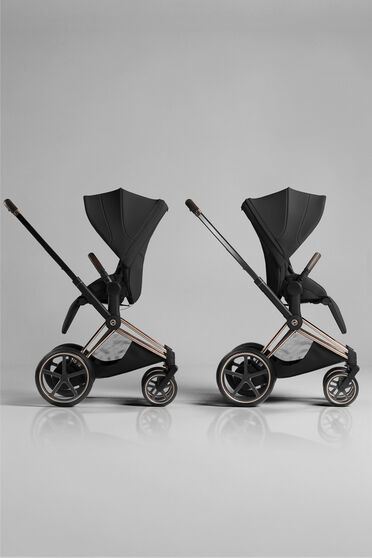 Two Priam strollers with seat units, one with a forward-facing position, one with a parent-facing one.