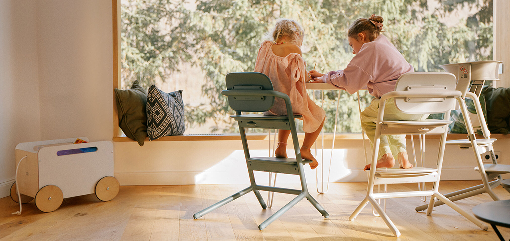 Zwei Kinder zeichnen an einem Tisch, die Kinder sitzen beide auf Lemo Hochstühlen