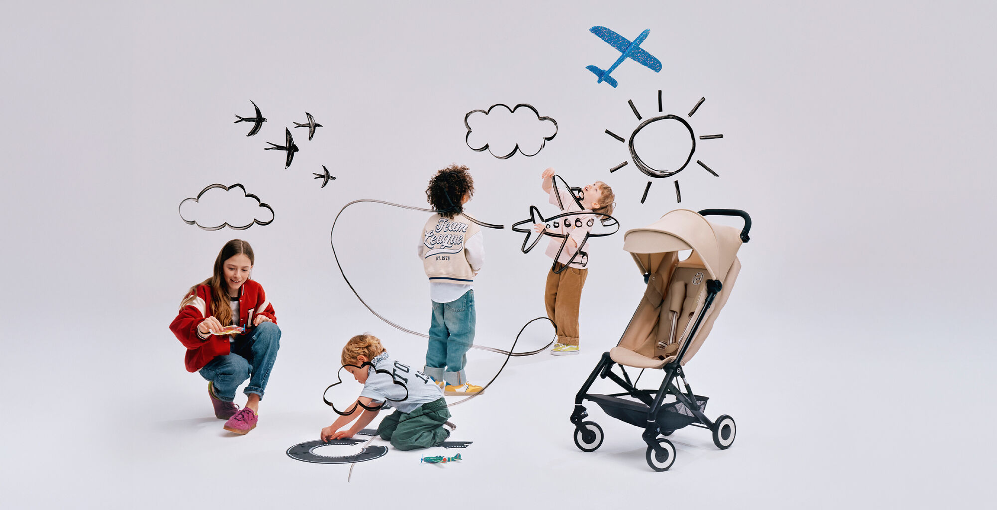 Fyra barn leker, en Agis resevagn bredvid dem. 