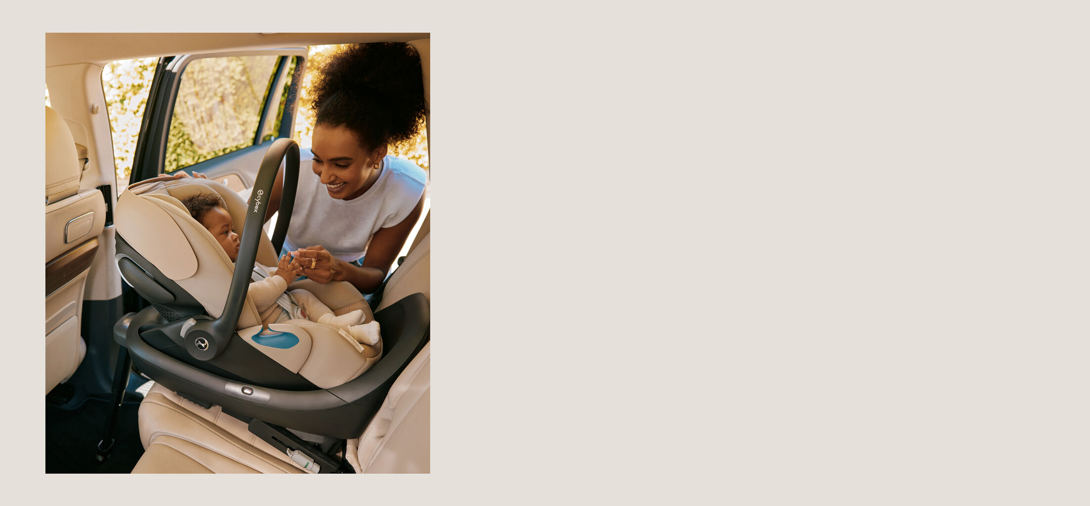 A mother leaning down to her child that is sitting in a Cloud G Pro Infant car seat in a rear facing position of a car.