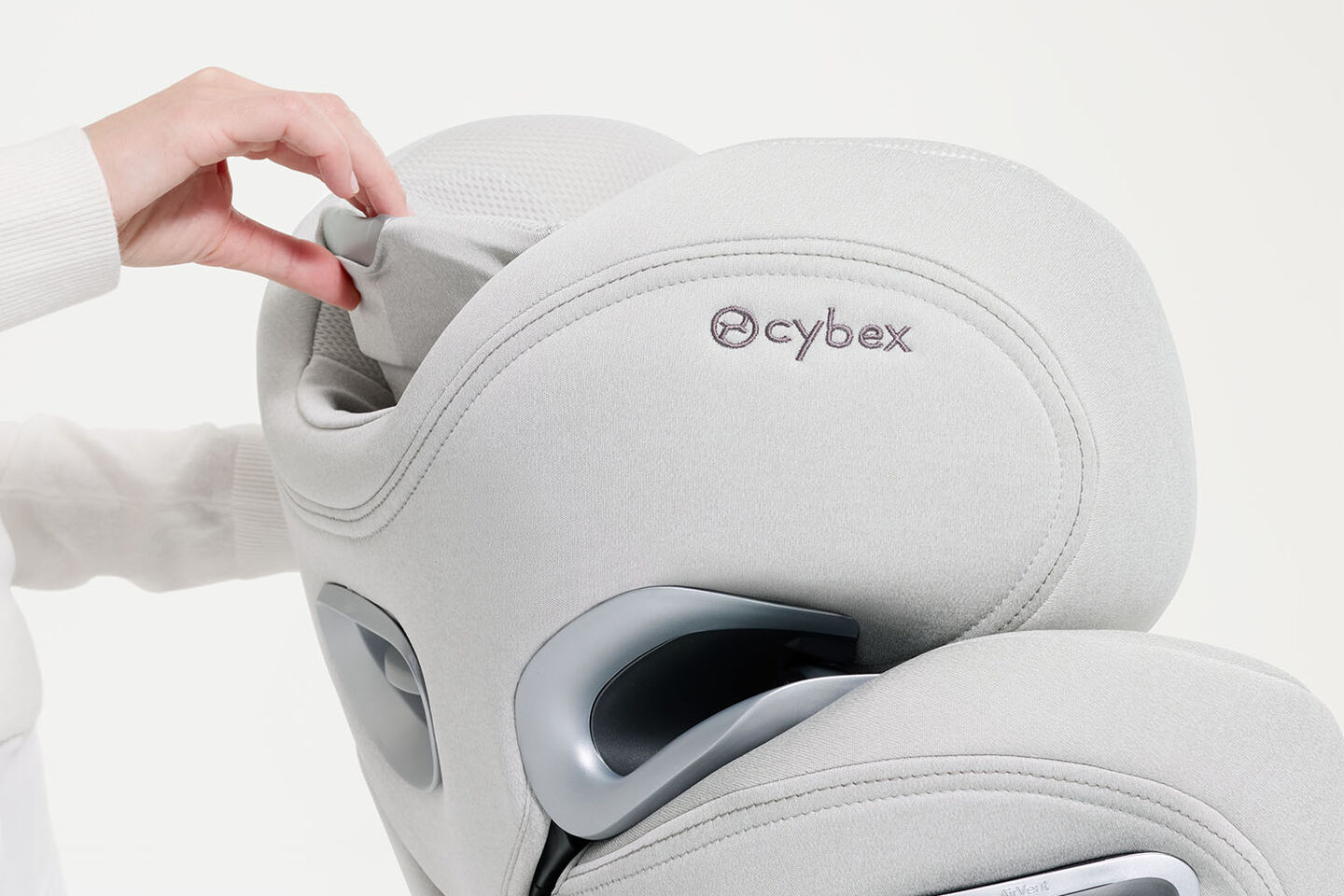 Woman pulling up the headrest of a CYBEX car seat.
