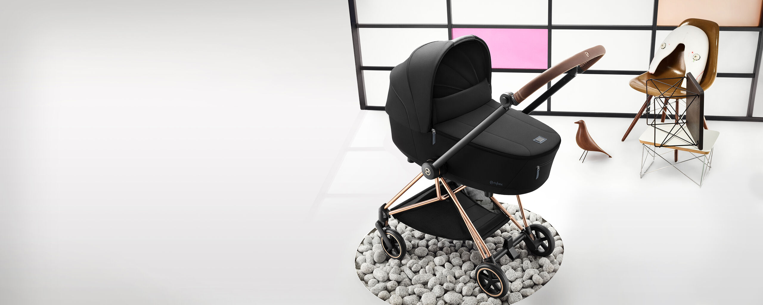 Mios stroller 3 in 1 with a modern design on a rocky surface.