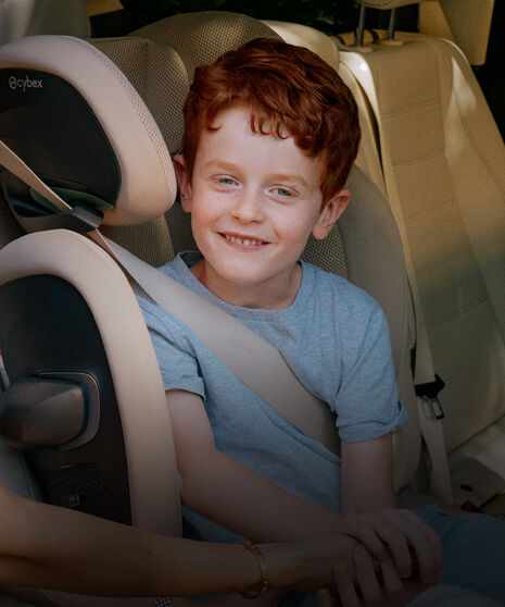 Image of a child sitting in a high-back booster car seat.