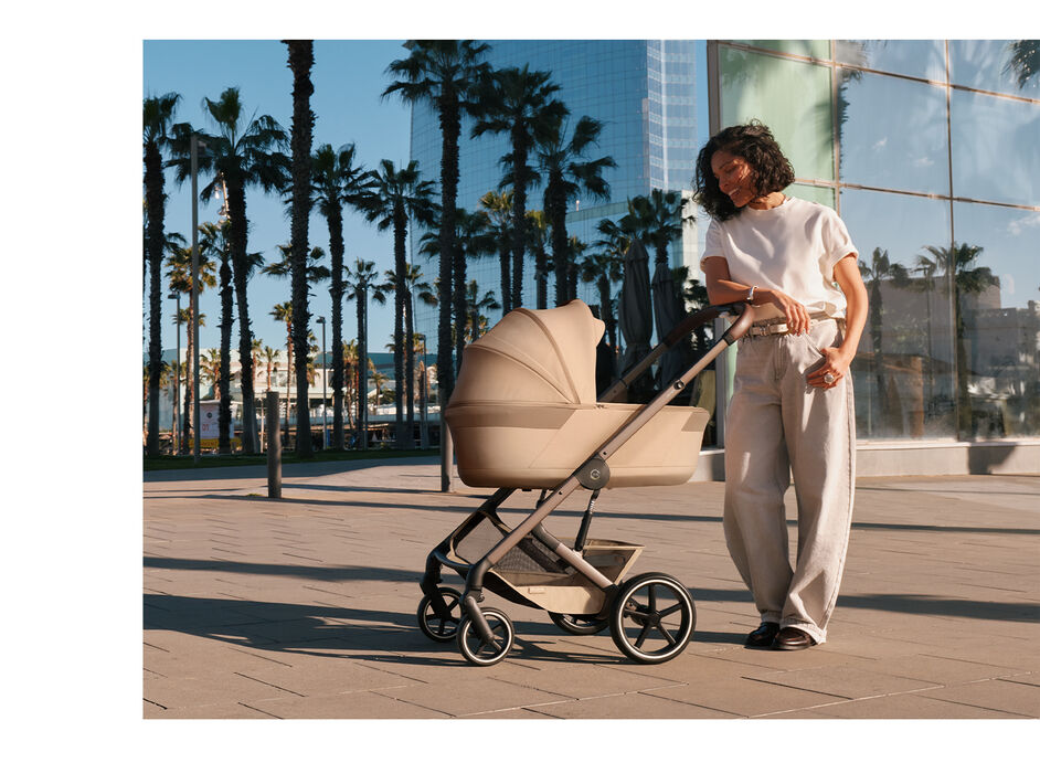 A mother looking down into the Foldable Cot on the Balios S Lux stroller.