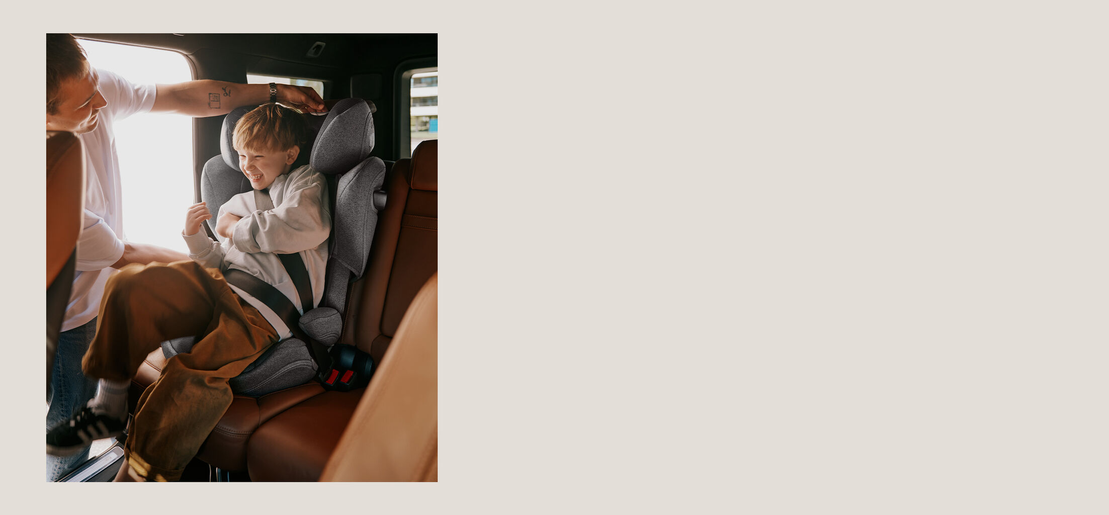A father tickling his son, sitting in a Solution T car seat.